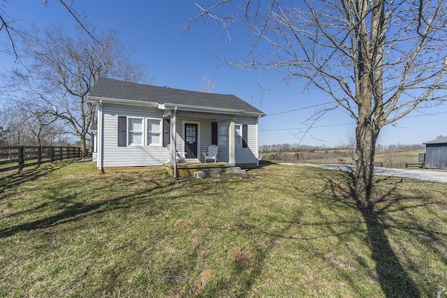 bungalow-style home featuring a shingled roof, a front yard, and fence