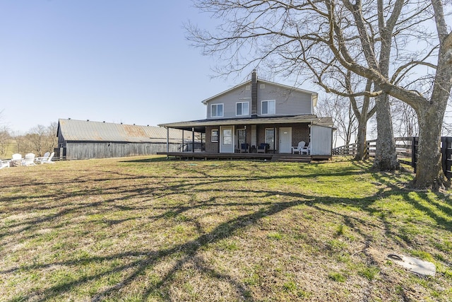 back of house featuring a yard, fence, and brick siding