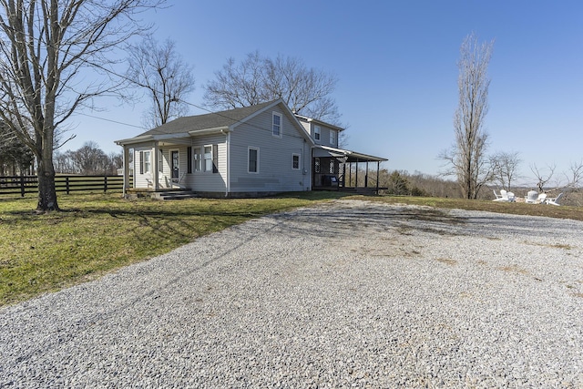 view of front of home featuring a front lawn, driveway, and fence