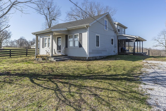 view of front of property featuring roof with shingles, a front yard, and fence