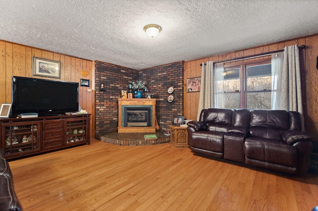 living area featuring a textured ceiling, wood finished floors, and wooden walls