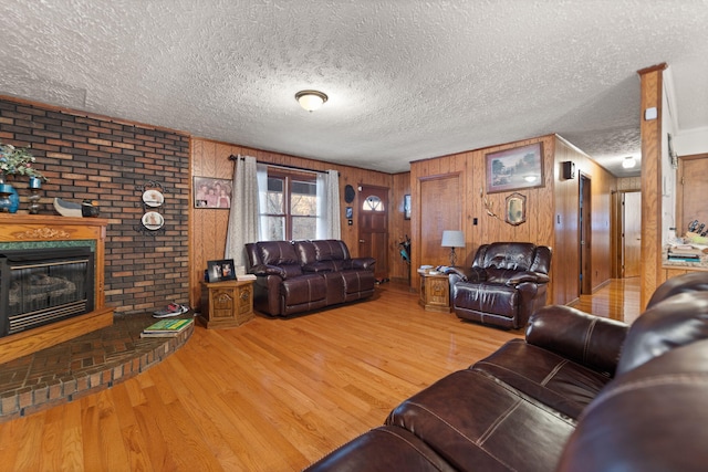 living area featuring a fireplace, a textured ceiling, and wood finished floors