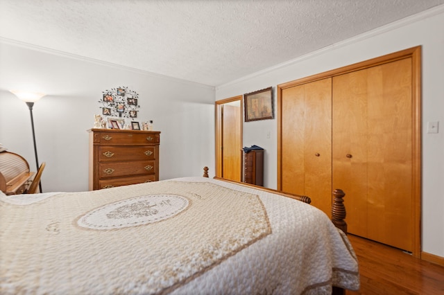 bedroom with a closet, ornamental molding, a textured ceiling, and wood finished floors