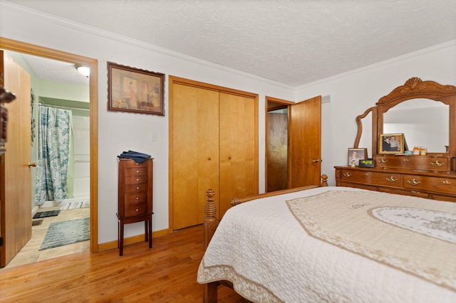 bedroom featuring ornamental molding, a textured ceiling, wood finished floors, connected bathroom, and a closet