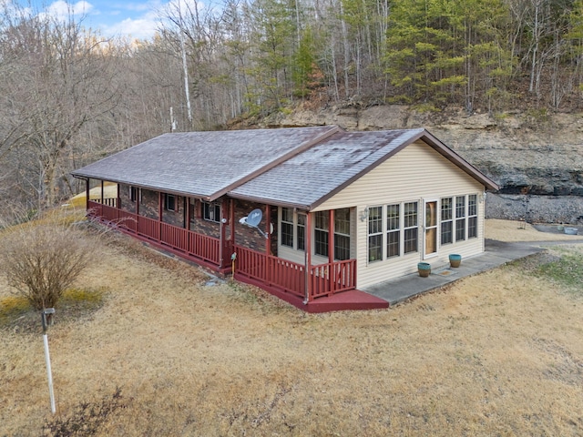 view of front facade featuring covered porch and a shingled roof