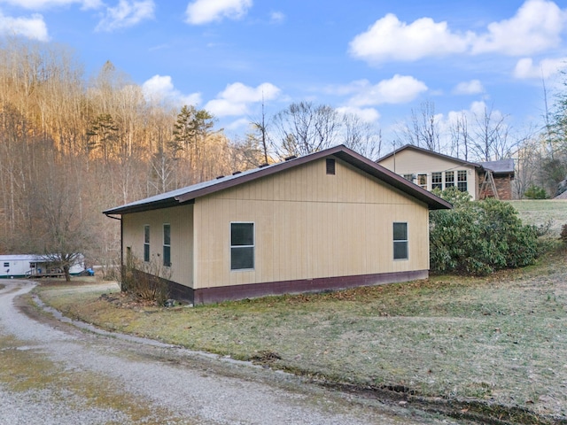 view of side of property with dirt driveway