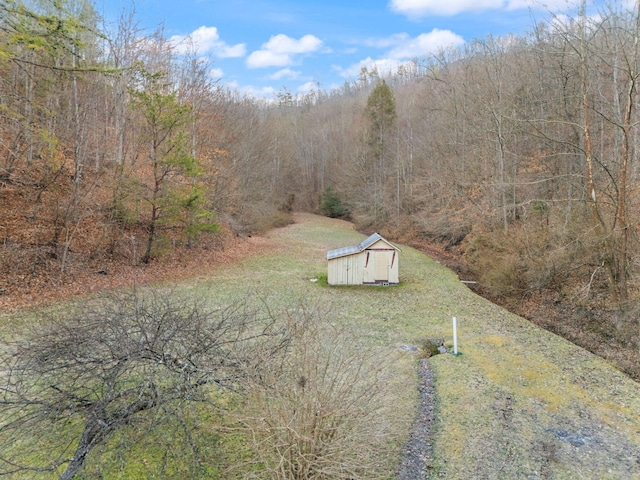 drone / aerial view featuring a wooded view