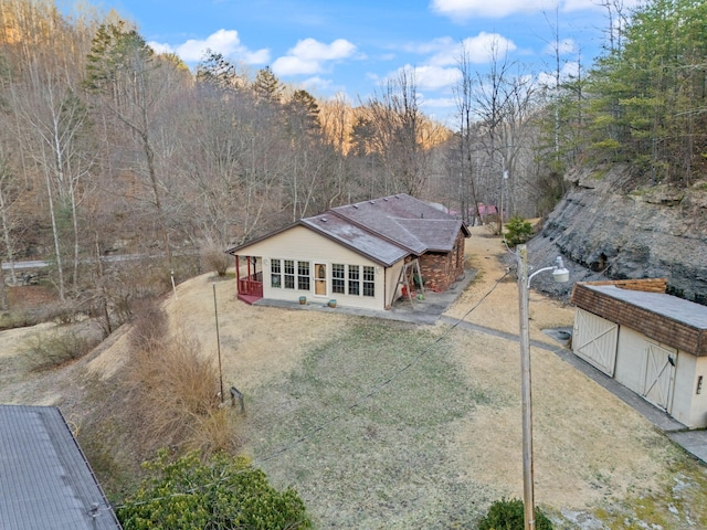 drone / aerial view featuring a wooded view