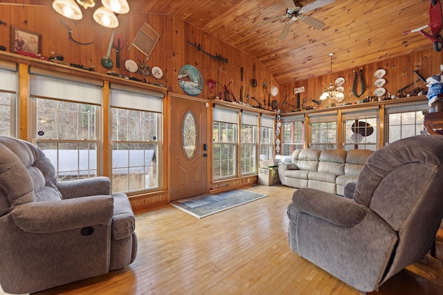 living room featuring wood walls, wood ceiling, and a healthy amount of sunlight