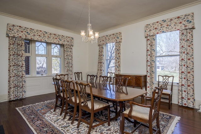 dining area with wood finished floors, plenty of natural light, an inviting chandelier, and ornamental molding