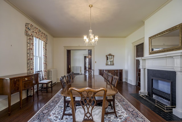 dining space featuring dark wood-type flooring, ornamental molding, radiator heating unit, baseboards, and a chandelier