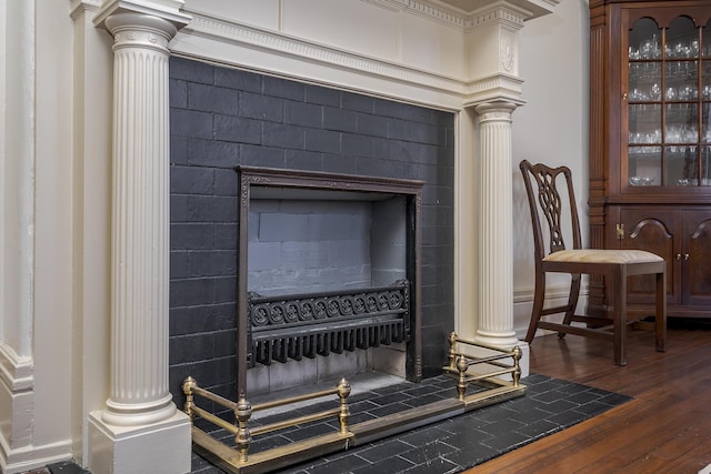 details featuring wood finished floors and decorative columns