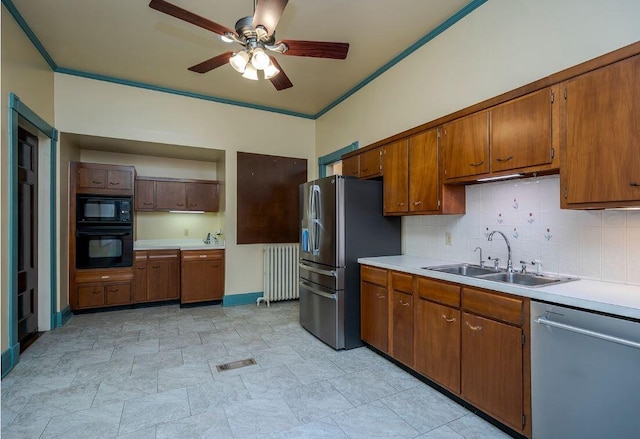kitchen featuring a sink, ceiling fan, light countertops, black appliances, and radiator heating unit