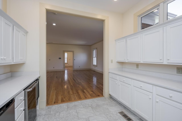 kitchen with visible vents, dishwasher, and white cabinetry