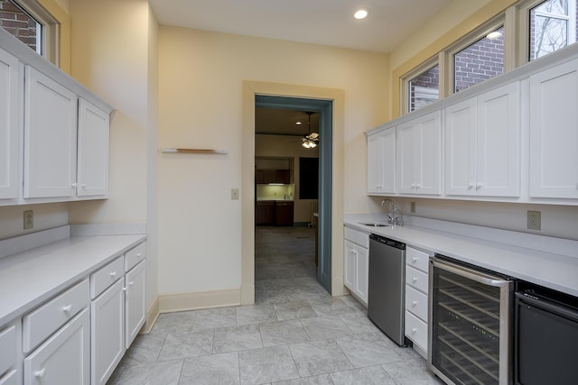 kitchen featuring beverage cooler, a sink, light countertops, white cabinets, and stainless steel dishwasher