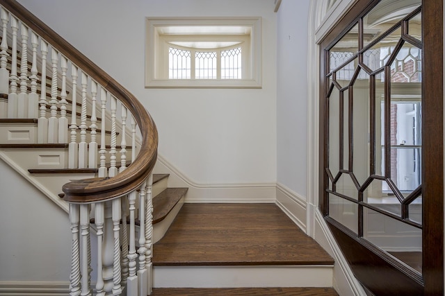 stairway with baseboards and wood finished floors