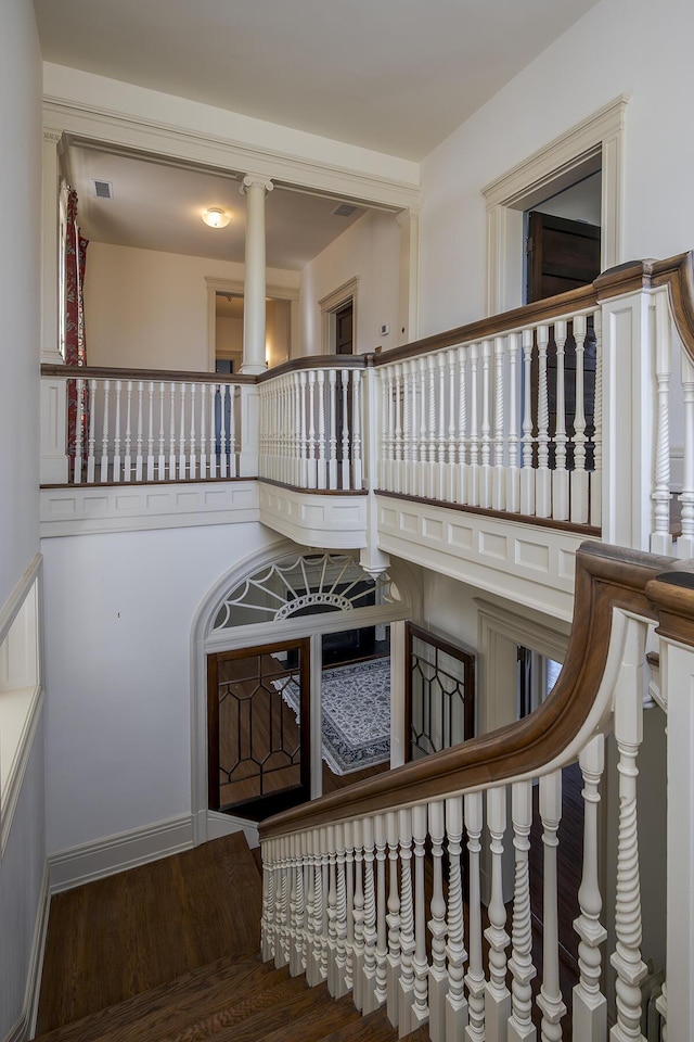 staircase featuring wood finished floors and visible vents