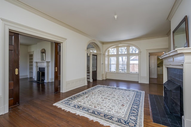 interior space featuring wood finished floors, crown molding, and a tile fireplace