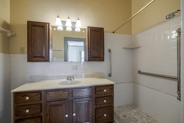 full bath with vanity, tile walls, and a tile shower