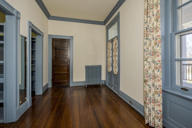 entryway with a healthy amount of sunlight, crown molding, radiator heating unit, and dark wood-type flooring