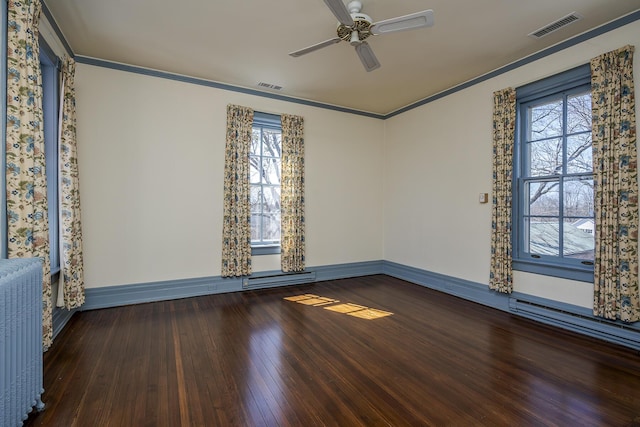 spare room with visible vents, crown molding, ceiling fan, radiator heating unit, and hardwood / wood-style flooring