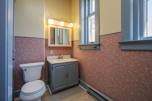 half bathroom featuring toilet, wallpapered walls, and vanity