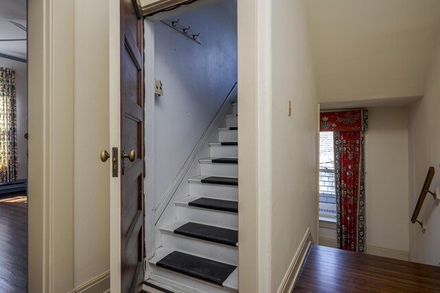 stairway with baseboards and wood finished floors