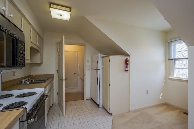 kitchen with baseboards, electric range oven, a sink, light countertops, and black microwave