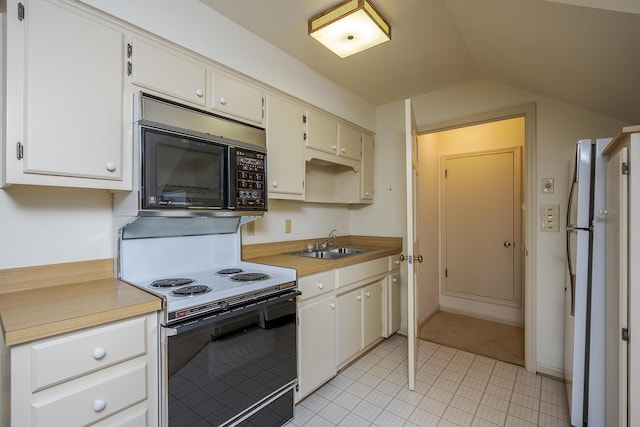 kitchen featuring range with electric cooktop, a sink, freestanding refrigerator, black microwave, and vaulted ceiling