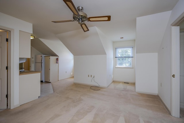 additional living space featuring light carpet, ceiling fan, and vaulted ceiling