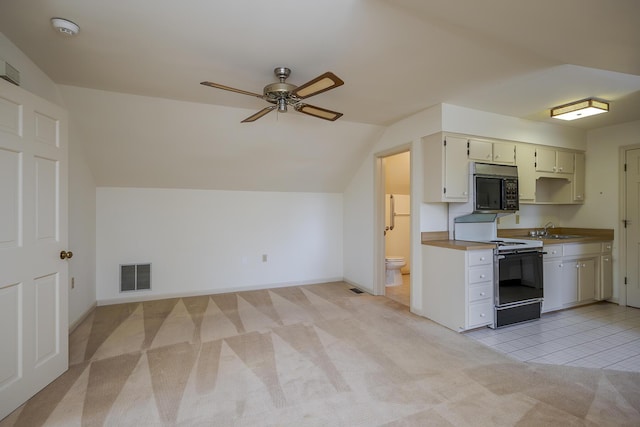 kitchen featuring visible vents, ceiling fan, light colored carpet, lofted ceiling, and black appliances