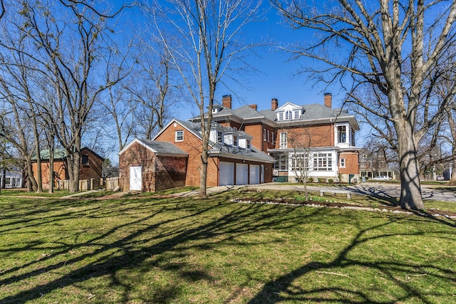 back of house with a yard, brick siding, and a chimney