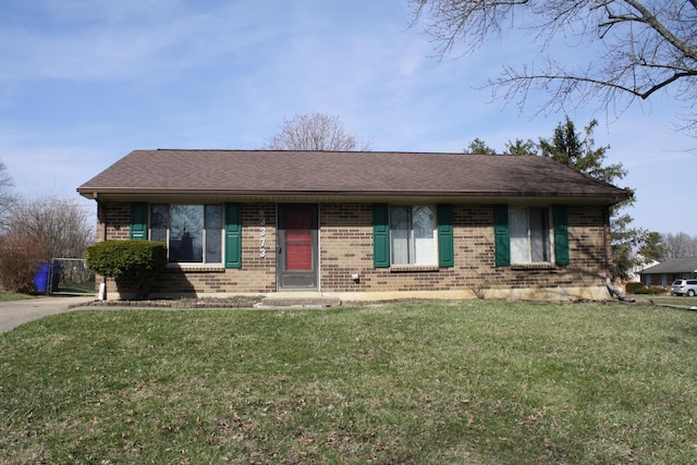 single story home featuring a front yard, brick siding, and a shingled roof