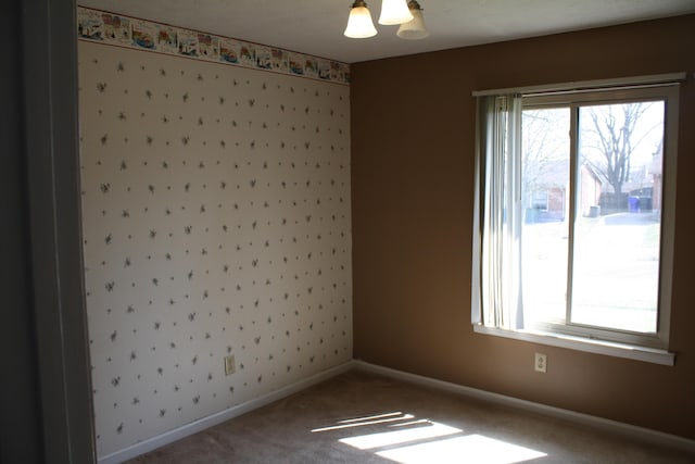 carpeted spare room featuring baseboards