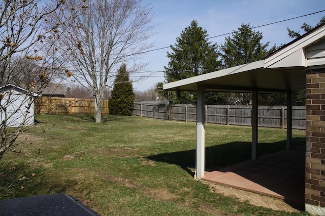 view of yard with an outdoor structure, a fenced backyard, and a storage shed