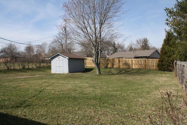 view of yard featuring an outbuilding, a storage unit, and a fenced backyard