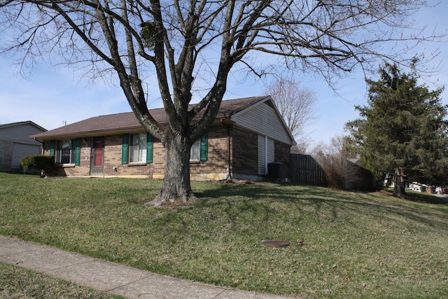 ranch-style house with a front yard, cooling unit, and brick siding