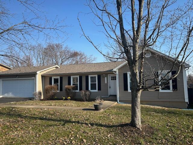 ranch-style house with a garage, driveway, and a front yard