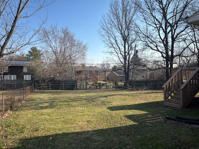 view of yard featuring stairway and fence