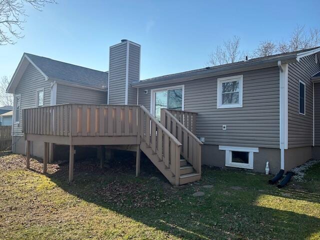 rear view of house featuring a yard, a wooden deck, a chimney, and stairway