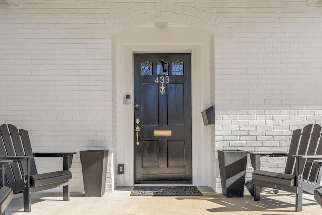 entrance to property featuring brick siding