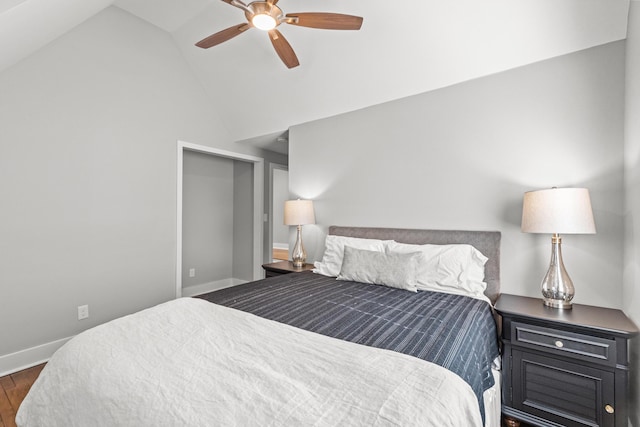 bedroom featuring a ceiling fan, wood finished floors, baseboards, and high vaulted ceiling