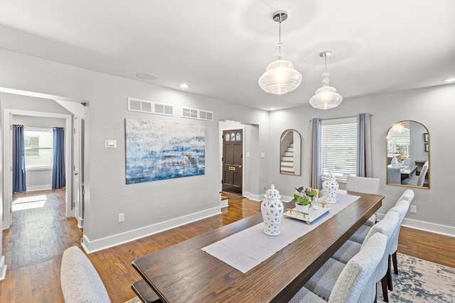 dining area featuring visible vents, baseboards, and wood finished floors