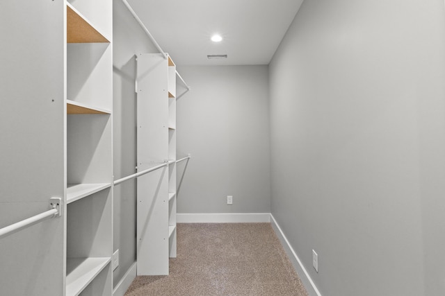 walk in closet featuring visible vents and light carpet