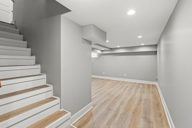 basement with stairway, recessed lighting, baseboards, and light wood-type flooring