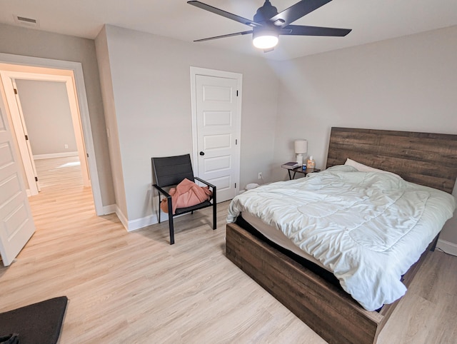 bedroom with light wood finished floors, visible vents, and baseboards