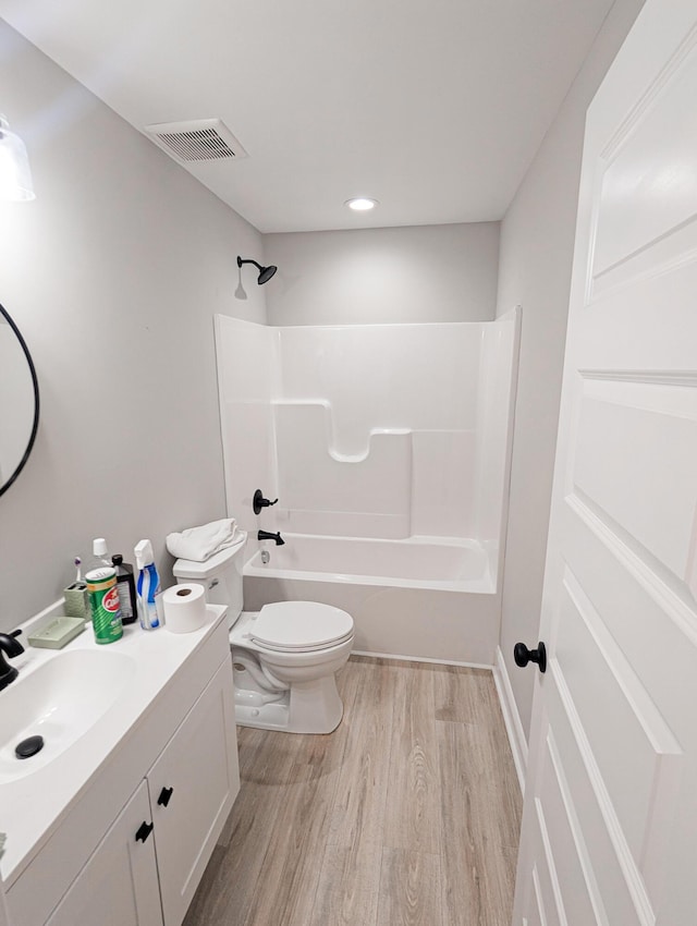 full bath with visible vents, toilet, shower / tub combination, wood finished floors, and vanity