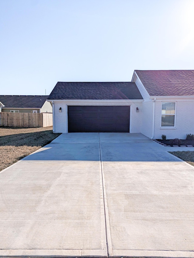 ranch-style home with concrete driveway, a garage, and fence