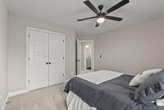 bedroom featuring light colored carpet, baseboards, a closet, and ceiling fan