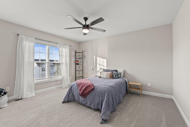 carpeted bedroom featuring baseboards and ceiling fan